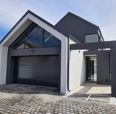 a modern house with two garages and an attached walkway leading to the front door