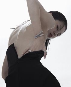 a woman in black dress posing with her hand on her hip and arm around her waist