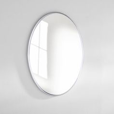 a white wall with a round mirror on it