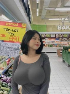 a woman standing in a grocery store with her hands on her hips