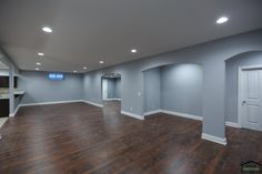 an empty room with hard wood flooring and white trim on the walls is lit by recessed lighting