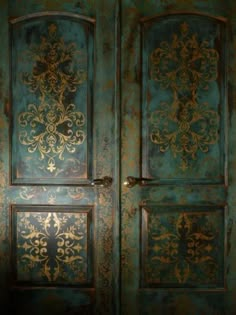 an ornately painted wooden door with gold and blue paint on the doors, which are decorated