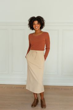 Perfect for everyday wear without loosing it's feminine essence, the 'Chamberlain' skirt will easily be an essential piece in your closet this fall! The skirt features a tie waistband, pockets, and is a modest midi length. Dress it up for a night out, or down for cozy day at home. 85% Polyester, 15% Cotton Unlined Hand Wash Cold Hang or Lay Flat to Dry Do Not Bleach Model Height 5'9" | Wearing Size Small Wearing the 'Nikki' Ribbed Striped Long Sleeve Top in rust with the 'Chamberlain' Tie Waist Modest Fall Skirt With Elastic Waistband, Fall Midi Skirt With Side Pockets, Casual Beige Skirt For Fall, Fall Daywear Skirt With Pockets, Modest Midi Skirt For Fall, Chic Fall Skirt With Tie Waist, Fall Pleated Skirt For Daywear, Everyday Fall Lined Skirt, Modest Fall Skirt