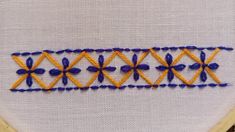 a close up of a piece of cloth with blue and yellow stitching