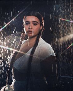 a woman with braids standing in the rain