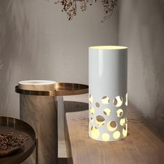 two vases sitting on top of a wooden table next to each other with lights in them