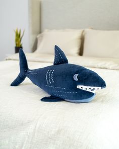 a stuffed shark is sitting on the bed