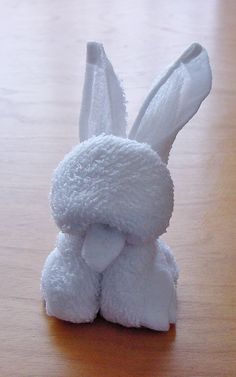 a white stuffed animal sitting on top of a wooden table