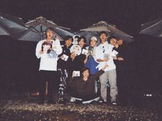 a group of people standing next to each other under umbrellas