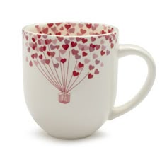 a coffee cup with hearts flying in the air on it's side and inside