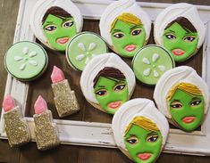 decorated cookies with green faces and gold glitters are displayed in front of a white frame