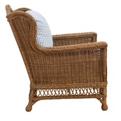 a wicker chair with white and blue pillows on it's armrests