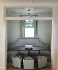 a room with a table, bench and two stools