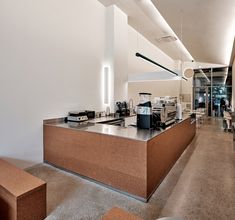 an empty restaurant with tables and benches in the middle of the room, along with a coffee machine on the counter