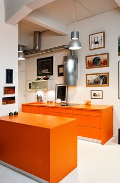 an orange desk in the middle of a room with pictures on the wall and ceiling