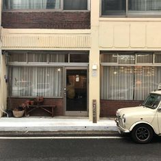 an old car parked in front of a building