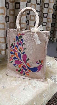 an embroidered bag sitting on top of a table next to a window with curtains in the background