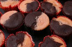 several chocolate cupcakes sitting on top of a black plate with red paper wrappers