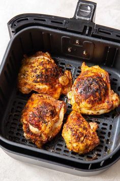 four pieces of chicken in a black air fryer