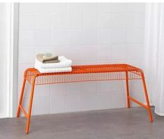 an orange metal bench with towels on it