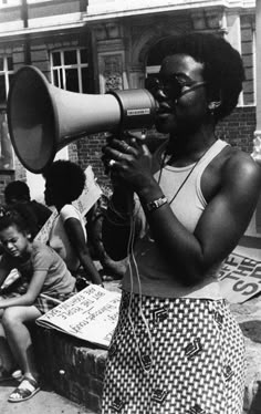 a black and white photo of a woman holding a megaphone