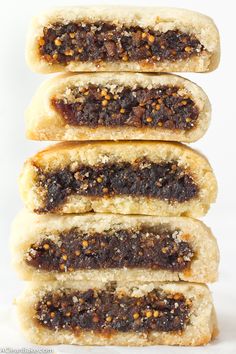 four pieces of bread with various toppings stacked on top of each other in front of a white background