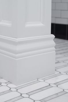 the corner of a white pillar on a tiled floor