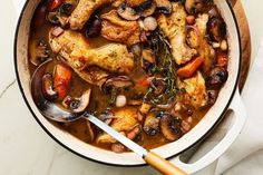 a pot filled with chicken and mushrooms on top of a table