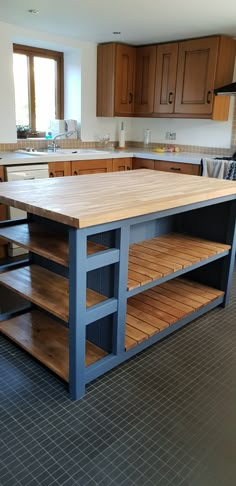 a kitchen island made out of wood and metal with shelves on each side for storage