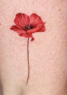 a red flower on the side of a woman's thigh