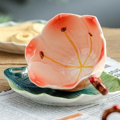 a pink flower sitting on top of a plate