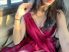 a woman in a pink sari sitting in the back seat of a car