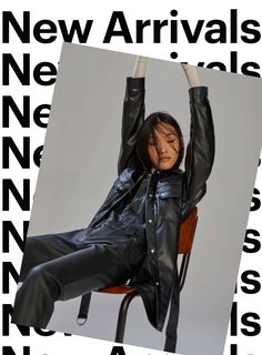 a woman sitting in a chair with her arms up and legs crossed, wearing black leather