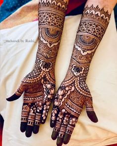 two hands with henna tattoos on them, one is showing it's intricate designs