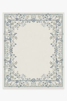 a blue and white rug with an ornate border on the bottom, surrounded by flowers