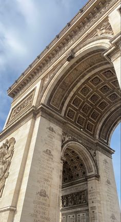 an arch with writing on it is in the middle of a blue and white sky