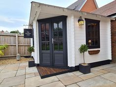 a small white building with black doors and windows