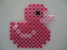 a pink bird made out of plastic tubes on a white surface with circles around it