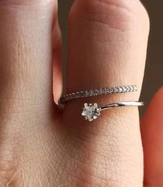 a woman's hand with a diamond ring on top of her finger and the bottom half