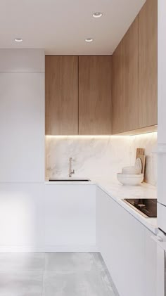 an empty kitchen with white counter tops and wooden cupboards on either side of the sink