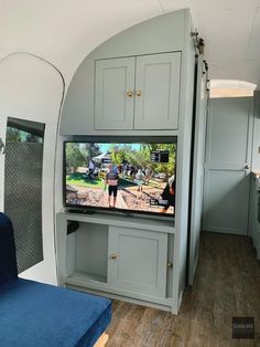 a living area with a couch, television and cabinets