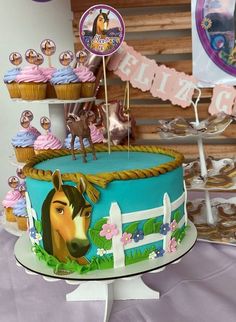 a horse themed birthday cake with cupcakes and decorations