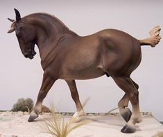 a statue of a horse walking on sand