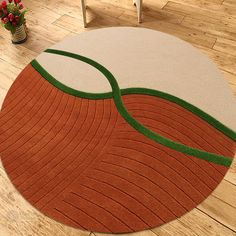 an orange and green rug on the floor in a living room with chairs, vases and potted plants