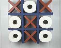 three rolls of toilet paper are hanging on a blue and red rack that is attached to a white door