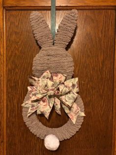 a door hanger with a bunny's head on it and a bow hanging from the front