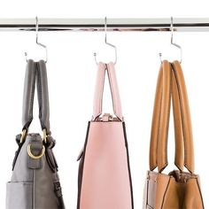 three purses hanging on a metal rack