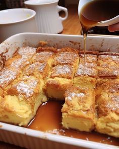 someone pouring syrup on some food in a pan