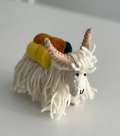 a small stuffed animal with horns and tassels