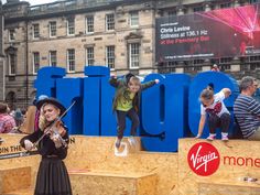 a group of people standing on top of a wooden structure with the word singgo written in large letters behind them